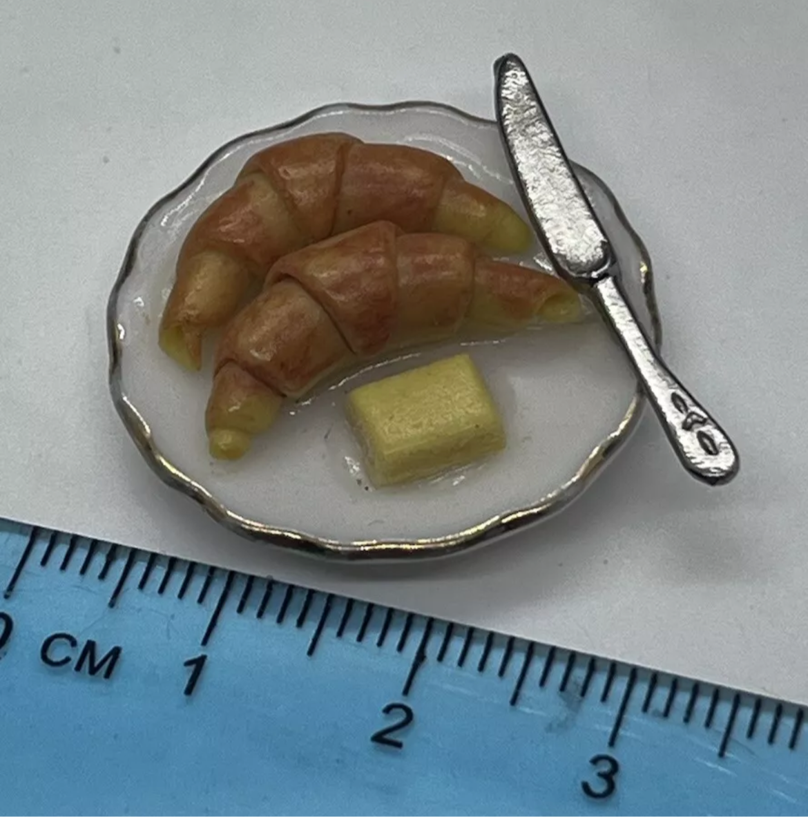 Dolls house croissant, butter & knife on plate
