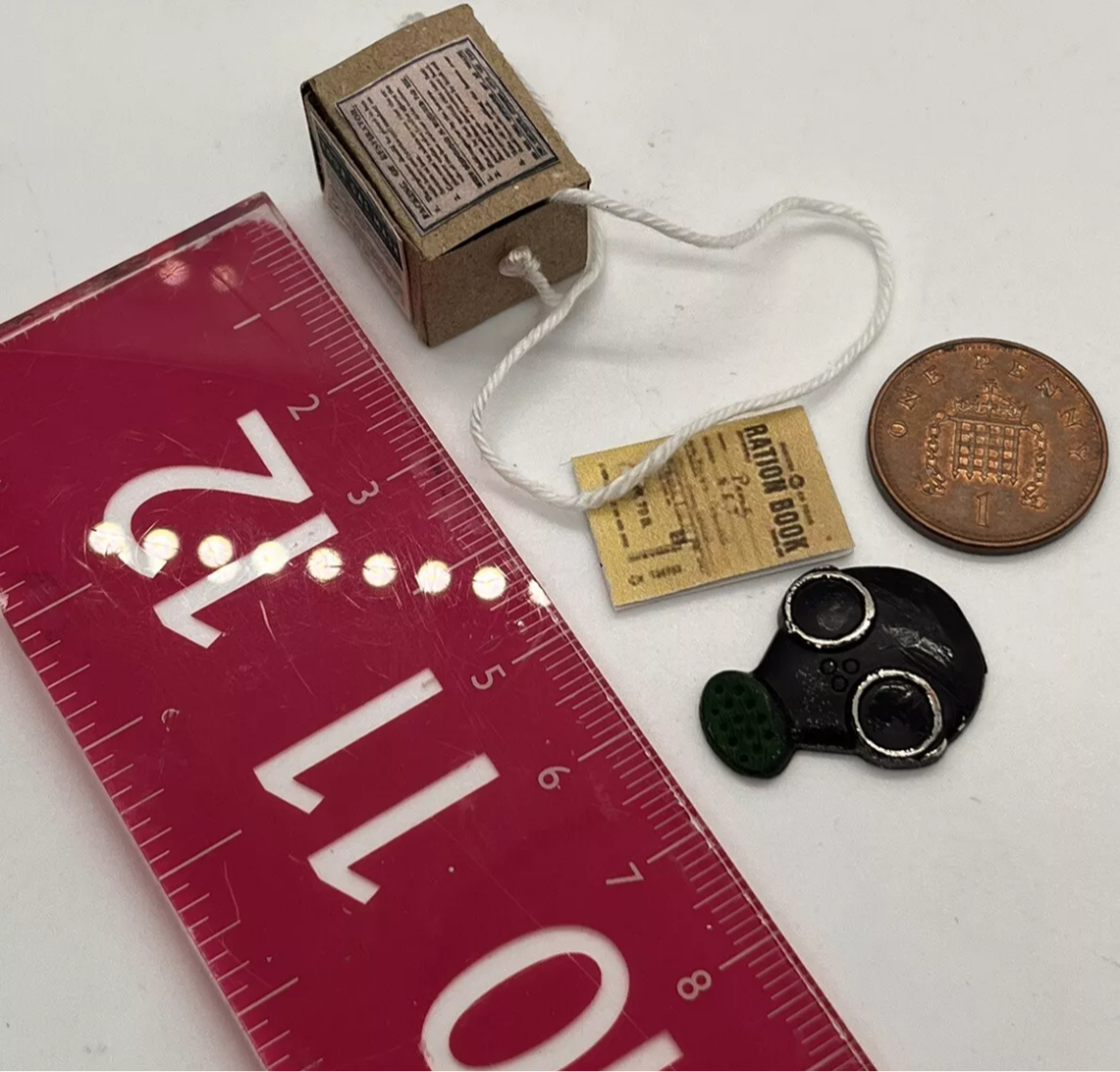 Dolls house has mask, ration book and gas mask box. (New)