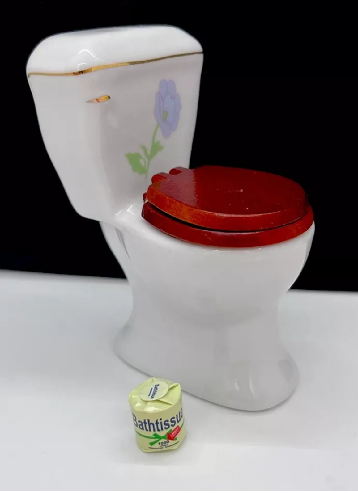 Dolls house toilet and toilet roll.