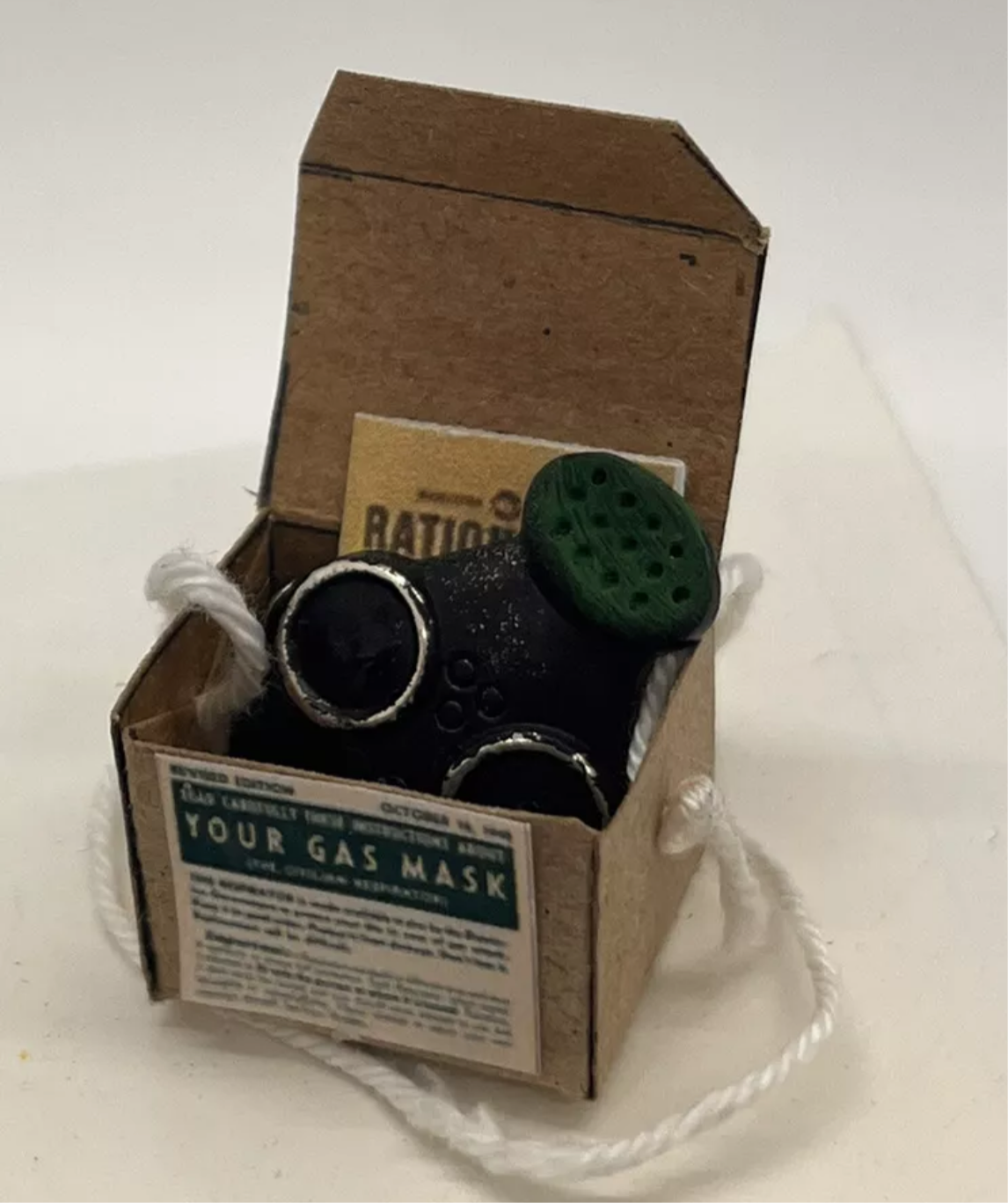 Dolls house has mask, ration book and gas mask box. (New)