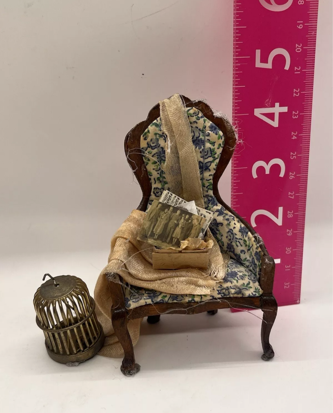 Dolls house old attic loft items, dusty backdrop. Old chair bird cage.
