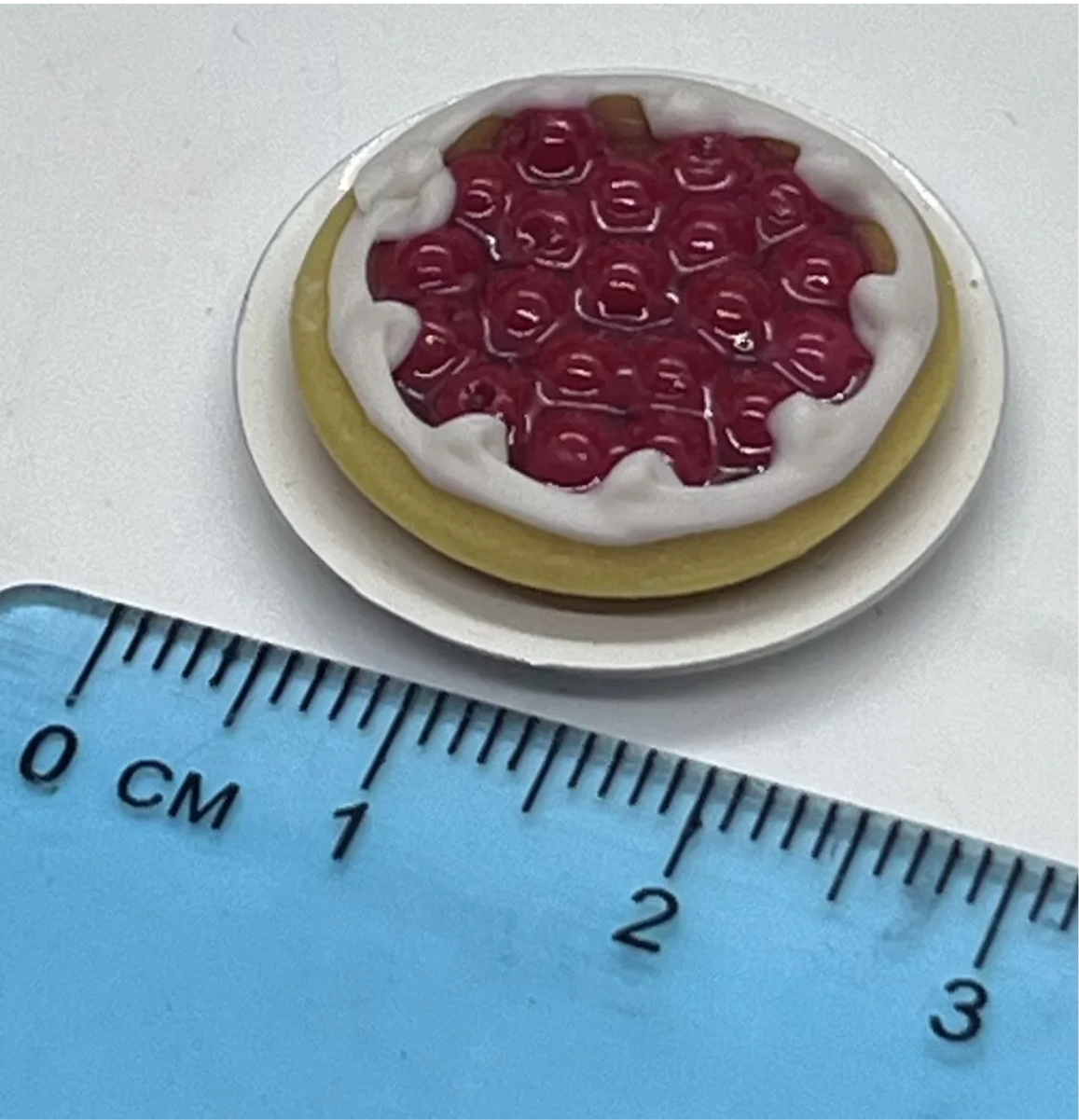 Dolls house cherry tart on a plate